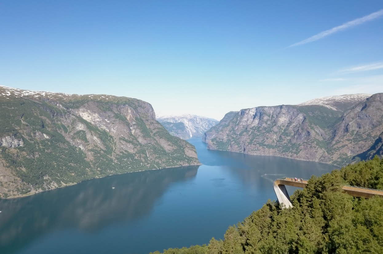 Une femme sur la plateforme d’observation du Stegastein, au-dessus de l’Aurlandsfjord, au coucher du soleil