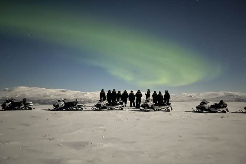 Arctic Train y experiencia de moto de nieve bajo el cielo nocturno