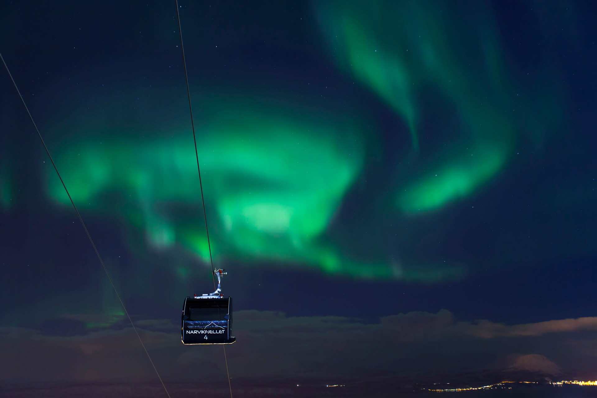 Téléphérique de Narvik sous un ciel illuminé par les aurores boréales.