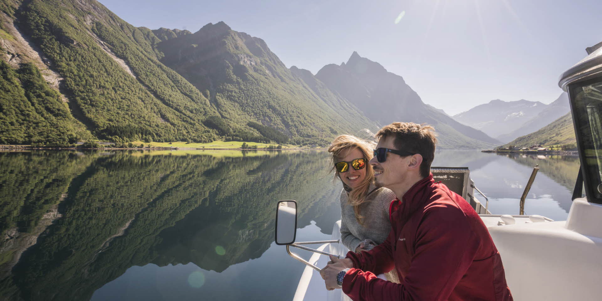 美しいヨルンフィヨルド(Hjørundfjord)でフィヨルドバイキング(Fjord Viking)船上にいる若いカップル