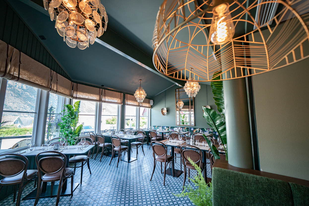 La terrasse d’hiver du restaurant de l’hôtel Aurlandsfjord, avec des lustres modernes au premier plan