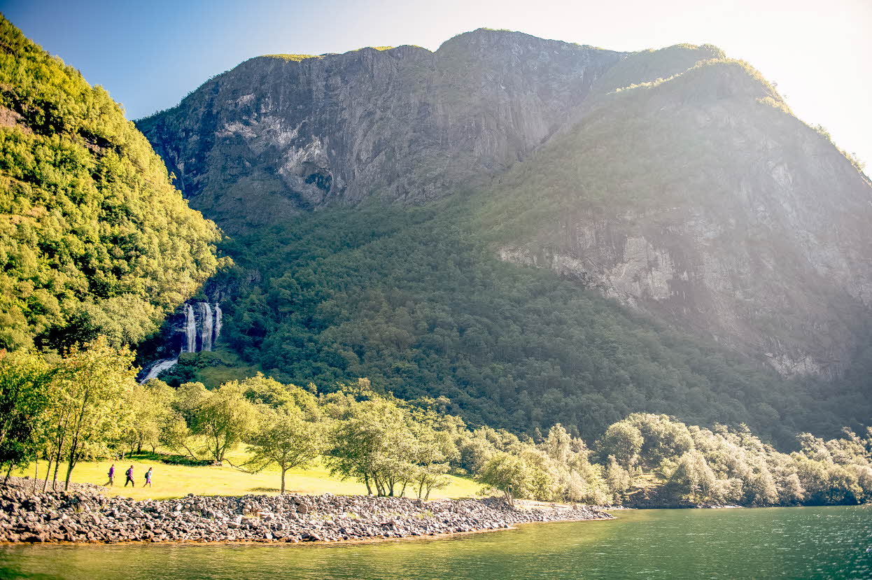 Randonneurs sur l’ancien Kongevegen au Nærøyfjord, avec une cascade en arrière-plan
