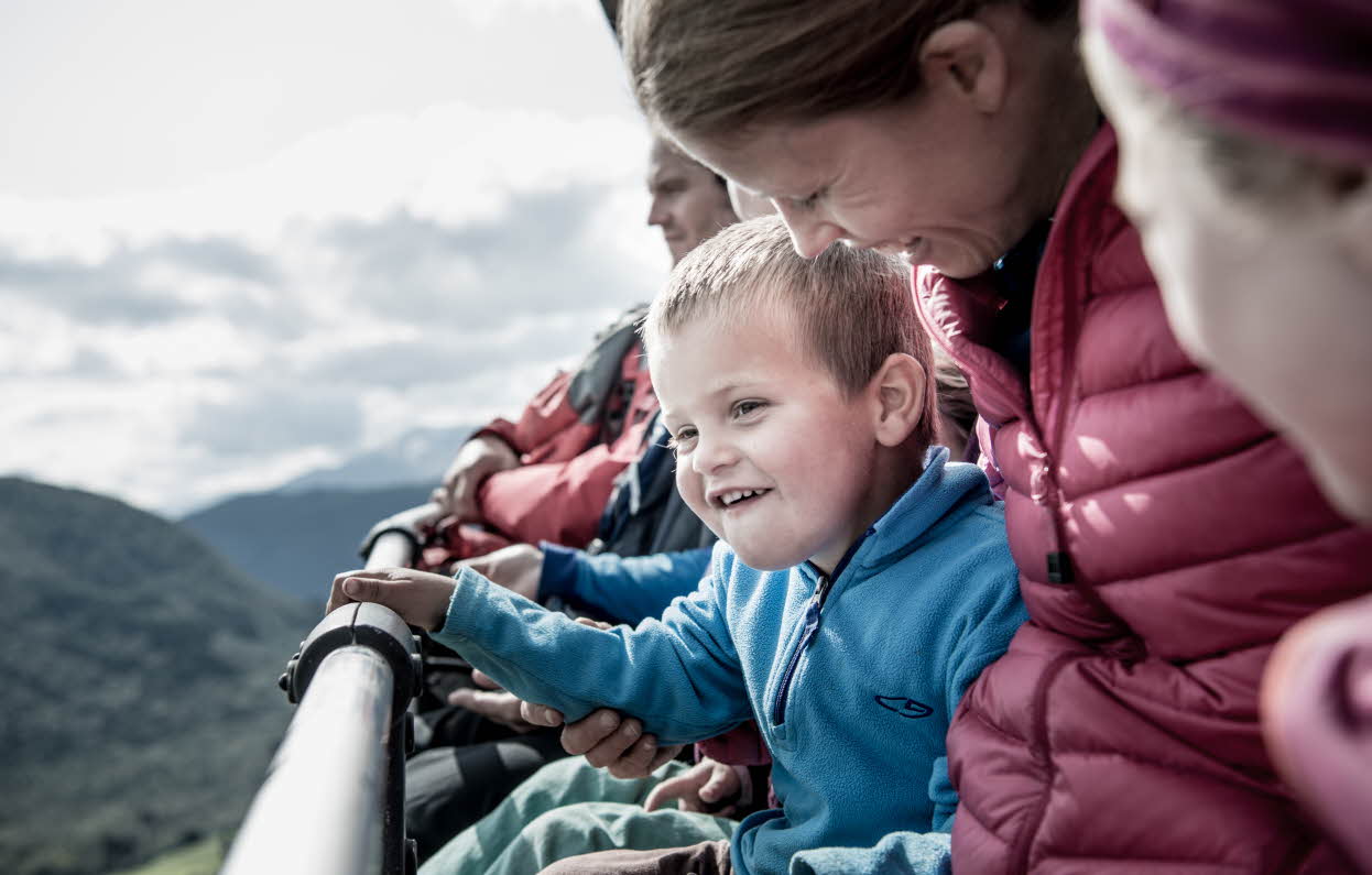 En familie sitter i stolheisen på veg til fjells i Myrkdalen