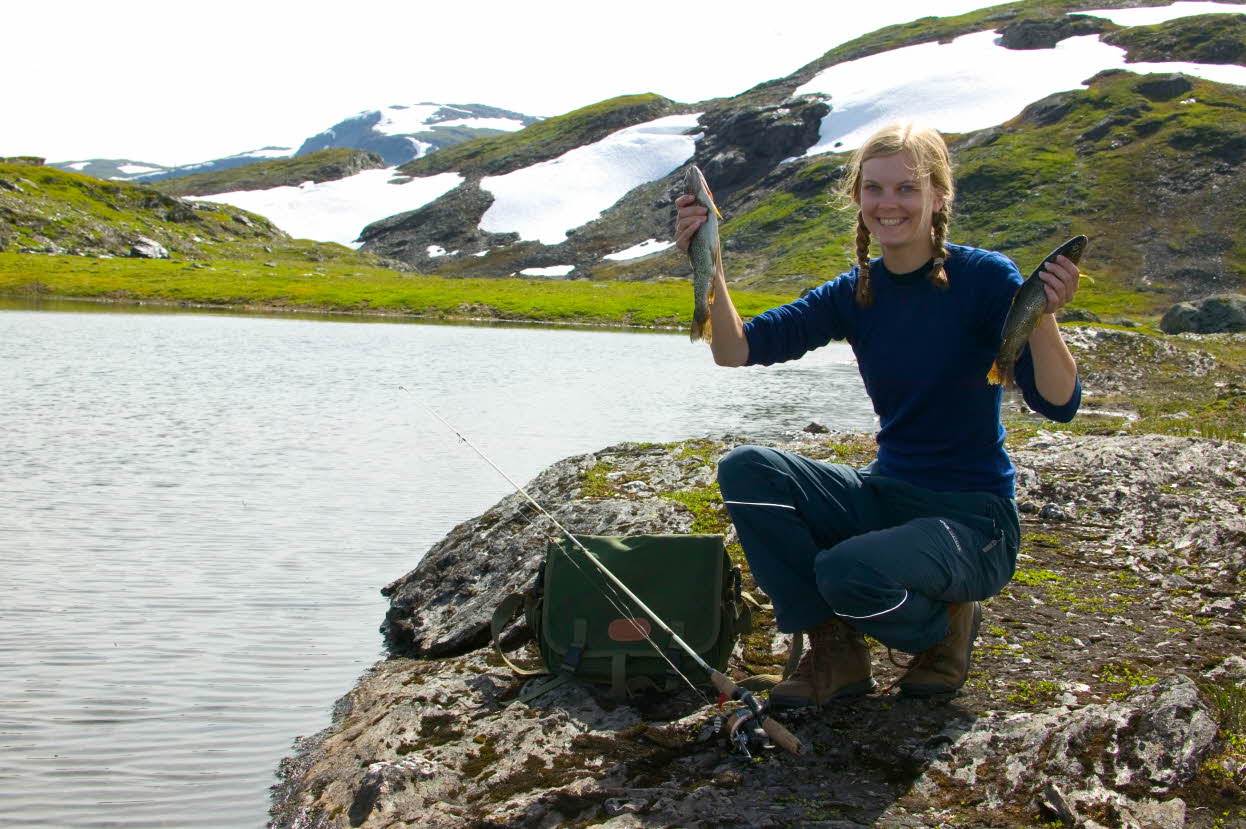 Tenåringsjente holder opp to ørreter på fisketur på Vikafjellet