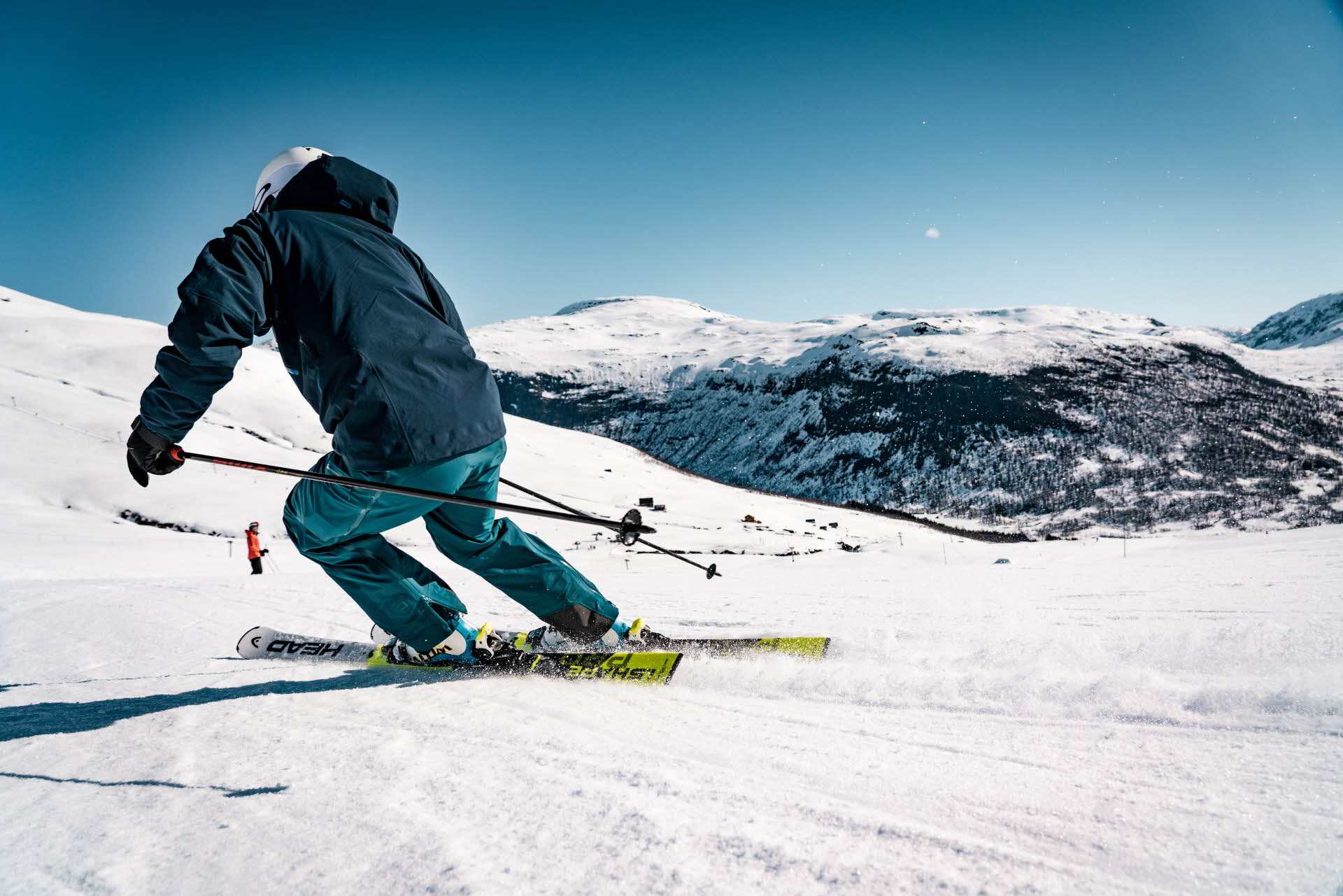 一个穿着蓝色滑雪服的男子在迈克达林 (Myrkdalen) 的山坡上滑雪
