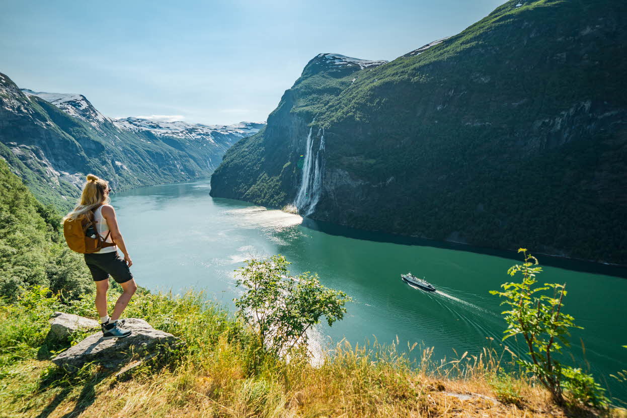 Une journée de début d’été au Geirangerfjord, avec une grande cascade et des sommets de montagnes enneigés