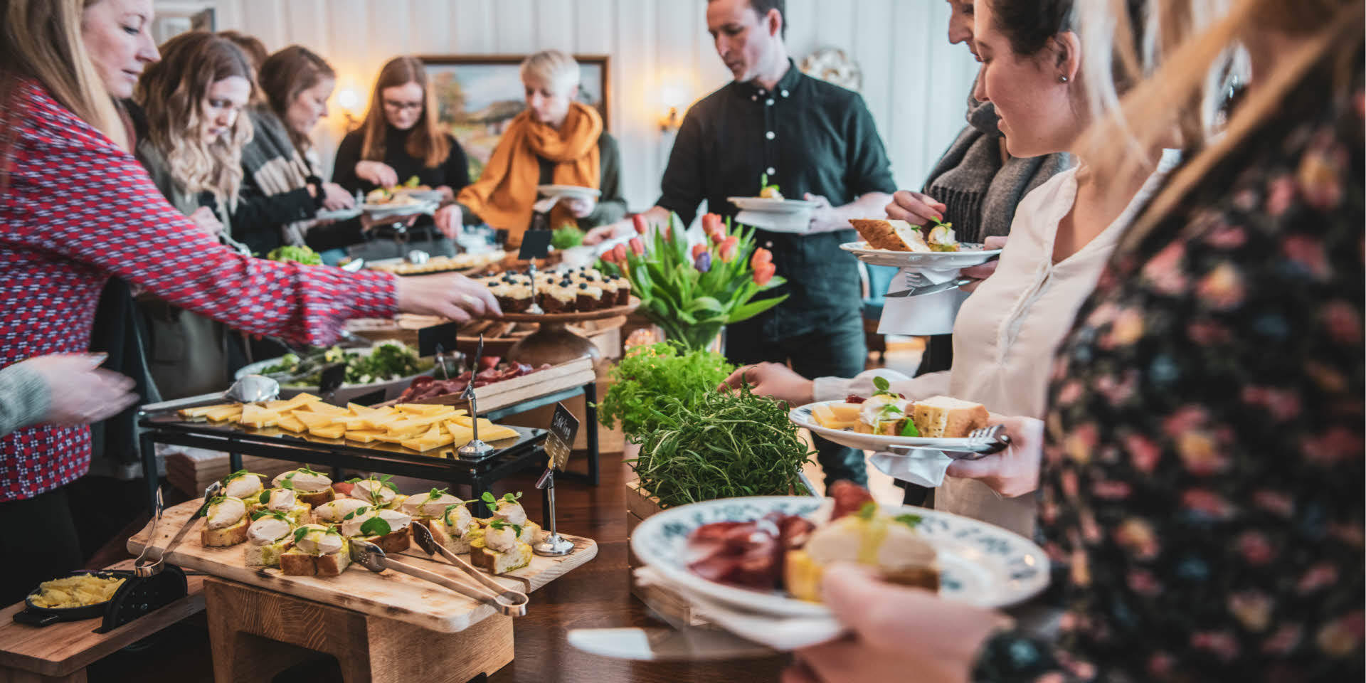Männer und Frauen bedienen sich an einem Buffet mit lokalen Tapasgerichten mit Salaten, Käse, Fisch und Wurstaufschnitt