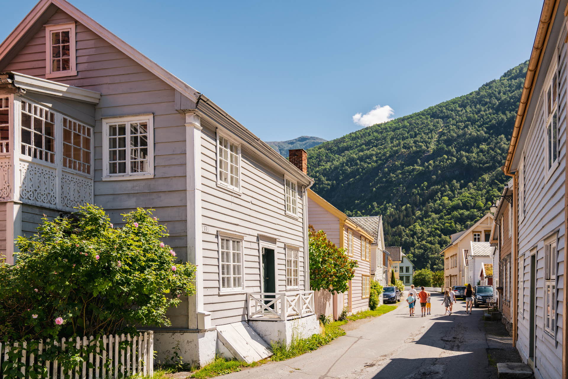 Acogedoras casas pequeñas en el casco antiguo de Lærdal durante un día de verano y 3 personas a lo lejos