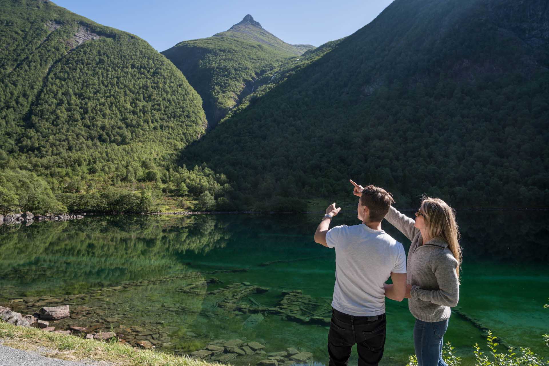 A woman and a man standing next to the ruins of the farm under the water in Norangdalen