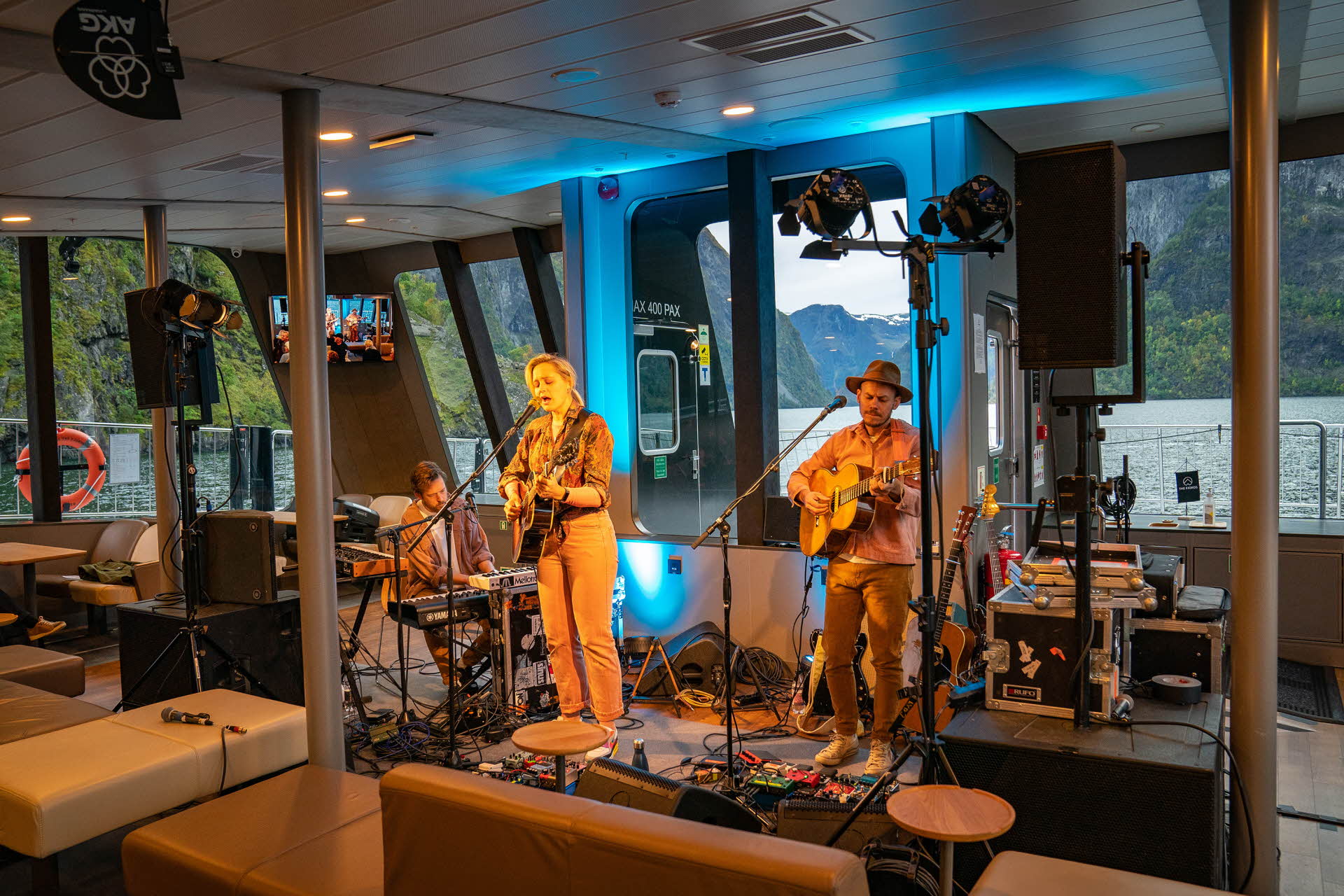 A band singing and playing on a boat on the Nærøyfjord.