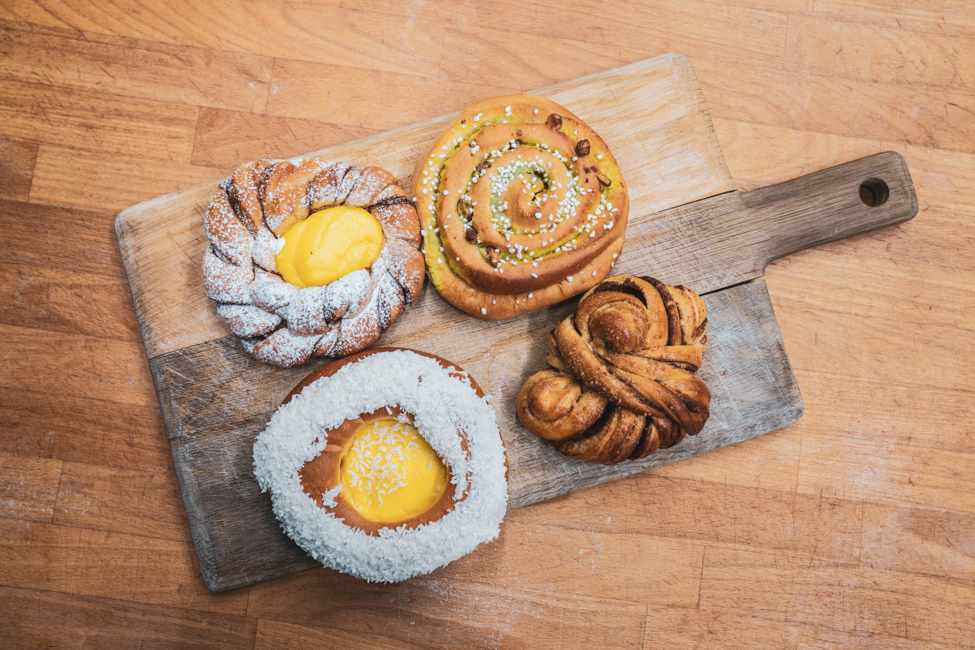 Breadrolls with egg in middle and cinnamon buns on wood plank
