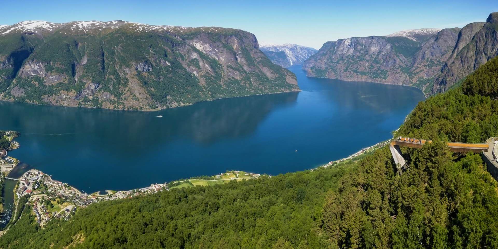 Panorama of Aurlandfjord in summer. Stegastein Viewpoint seen from above with people overlooking the unesco listed fjord