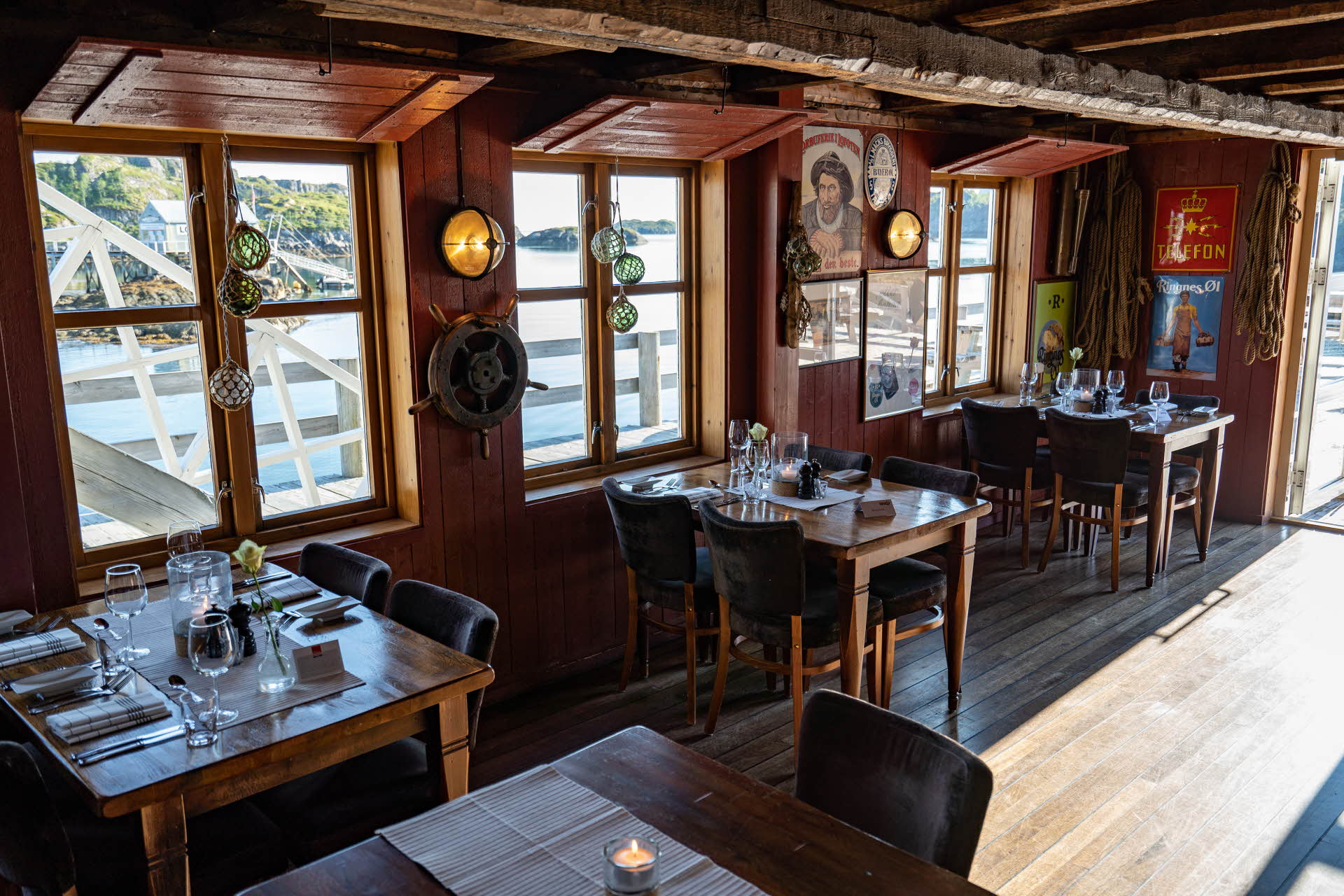 Restauranten på Nyvågar Rorbuhotell. Tre oppdekede bord og solskinn på gulvet. 