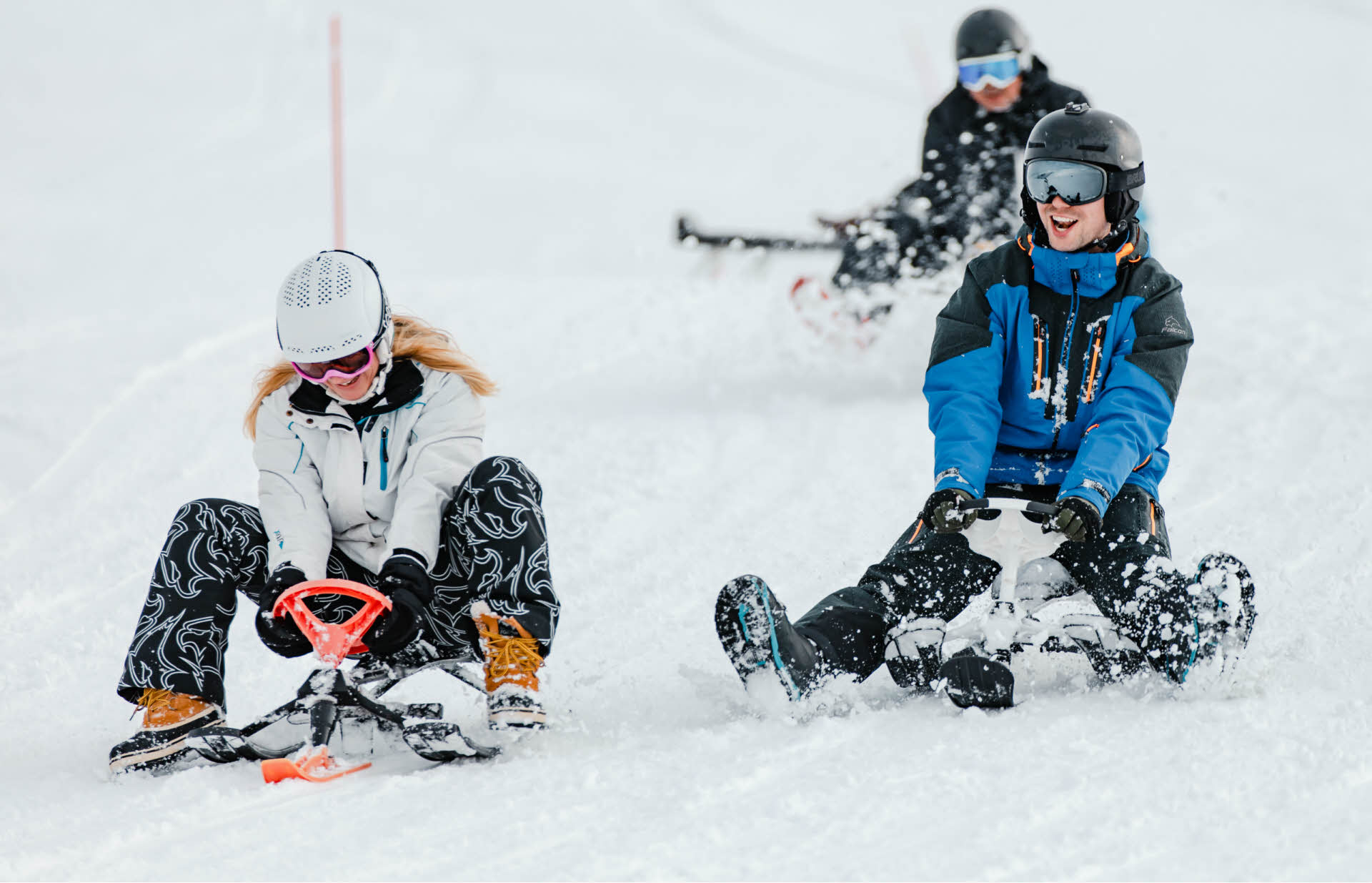 Trois personnes descendant en luge les pistes de ski de Myrkdalen 