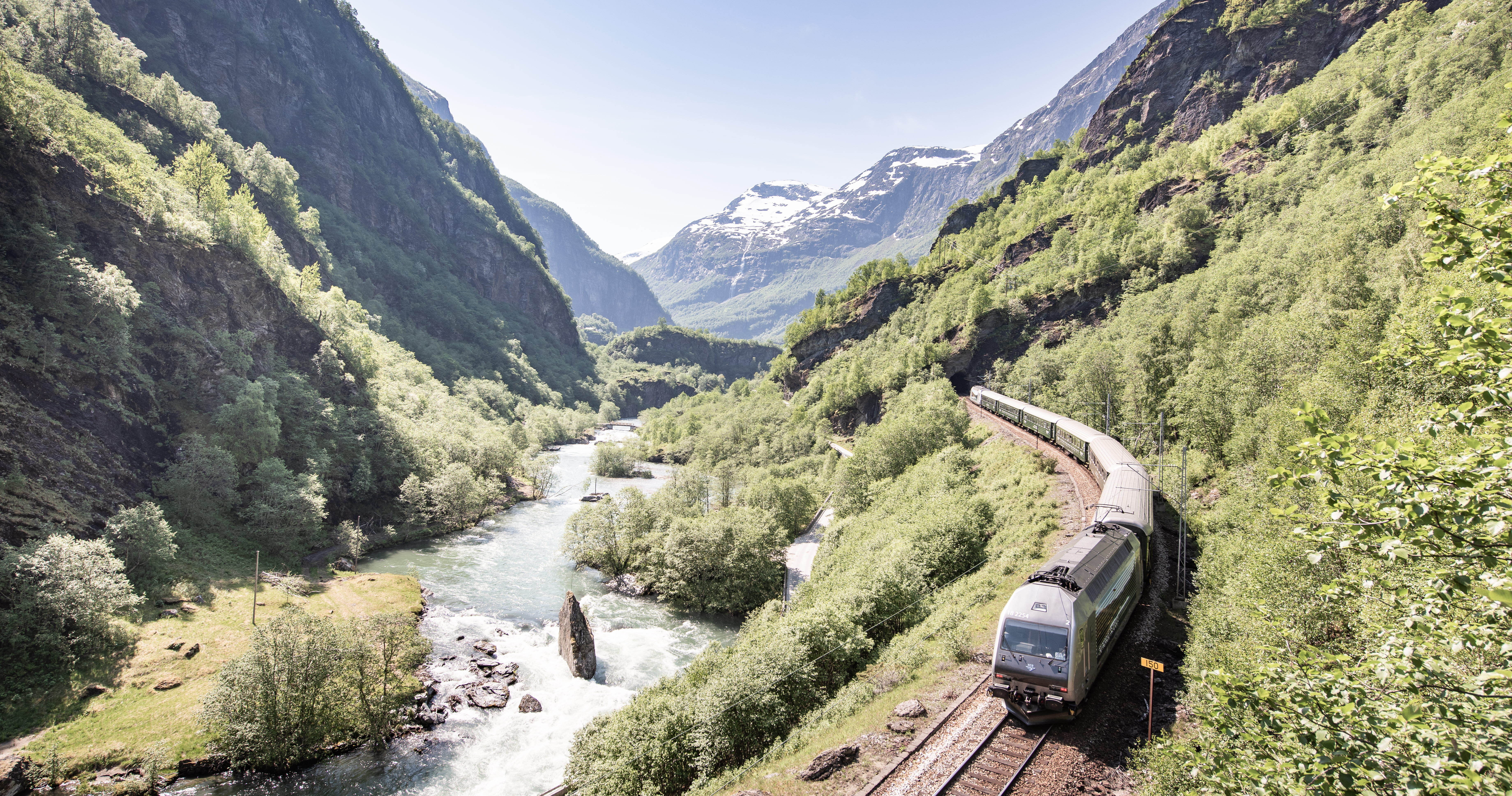 The train on the Flåm Railway, heading down the valley next to the turquoise river