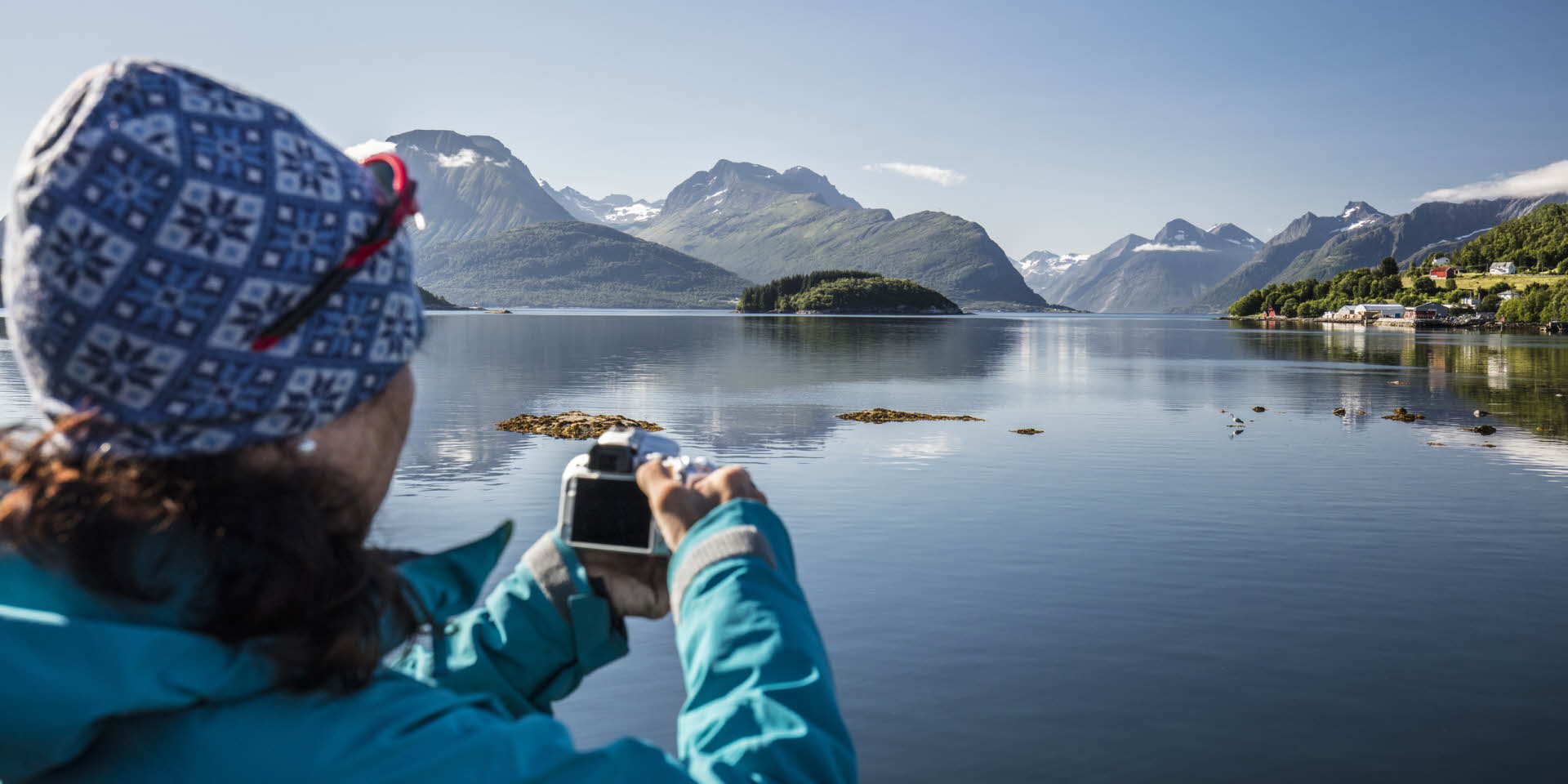 フィヨルドクルーズ船上で写真を撮る女性 ヨルンフィヨルド(hjørundfjord) 美しいフィヨルド 