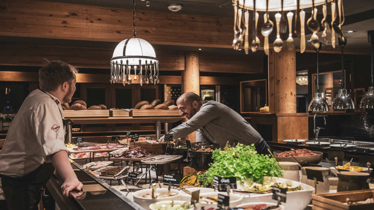A chef and a waiter setting a buffet in restaurant Arven.