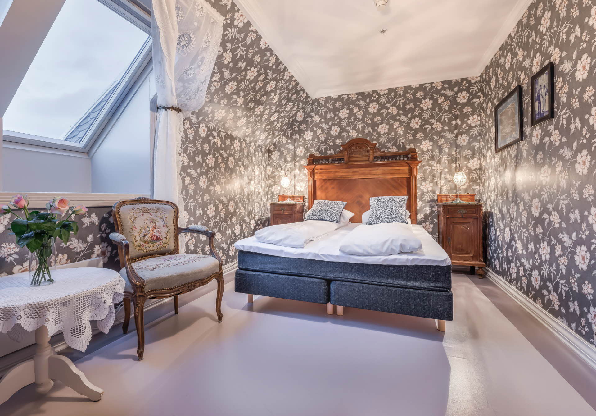 アンティークの家具や壁紙が特徴のグロッペン ホテルの歴史ある客室。 