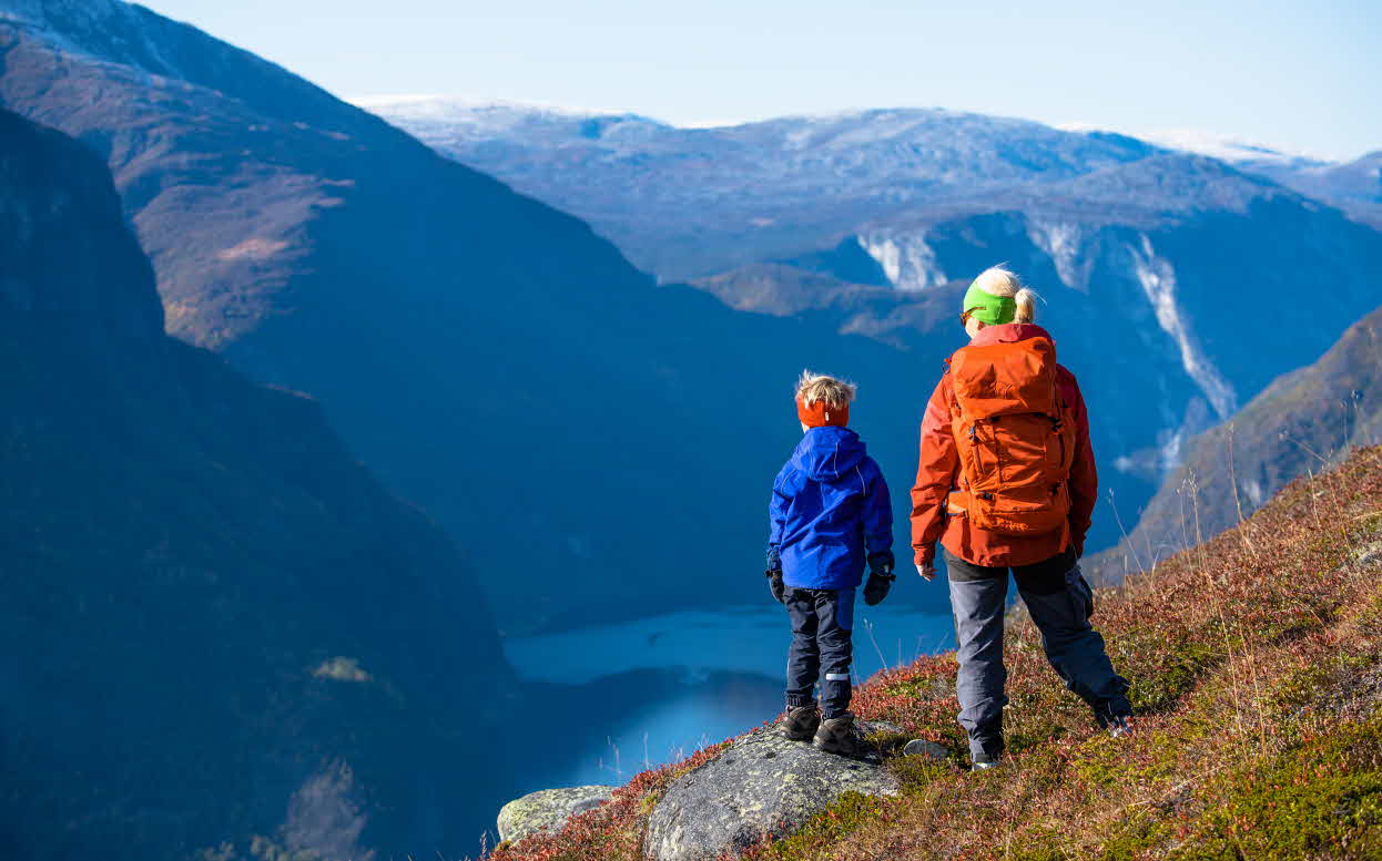 A boy and a woman looking down towards the Aurlandsfjord on their way up to Prest