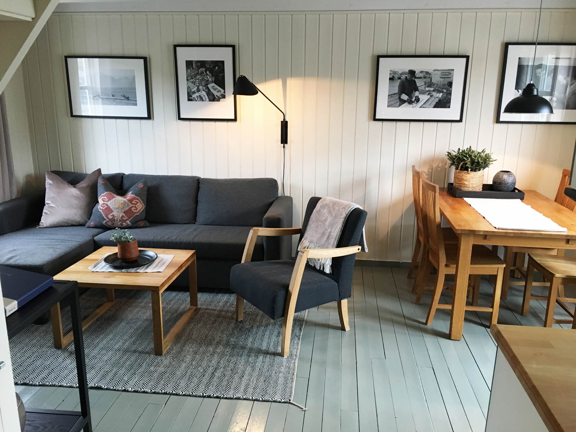Interiør i en rorbu hos Nyvågar Rorbuhotell. Sofagruppe og spisebord i lyse farger.