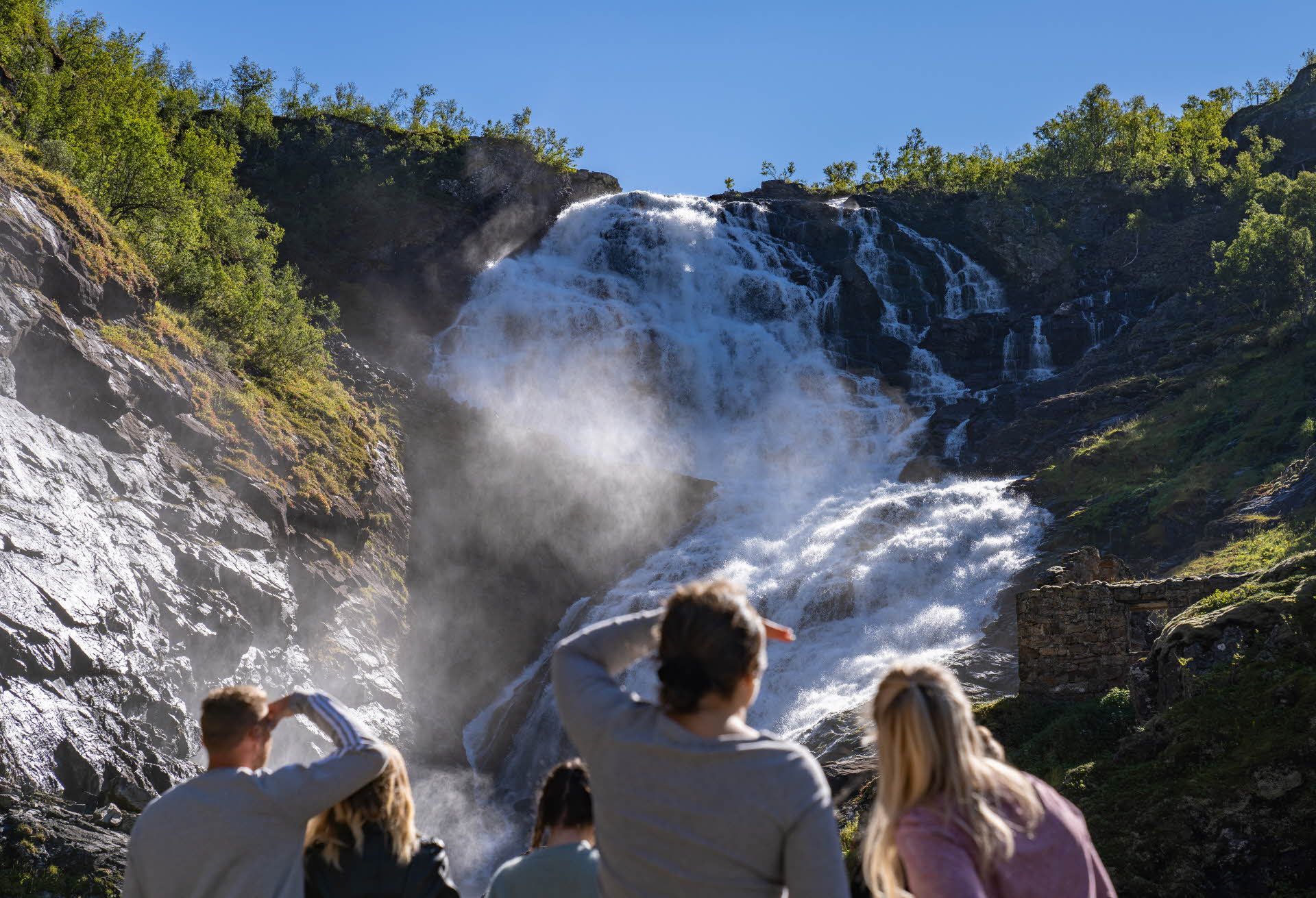 Des touristes admirent la cascade de Kjosfossen et la danse Huldra