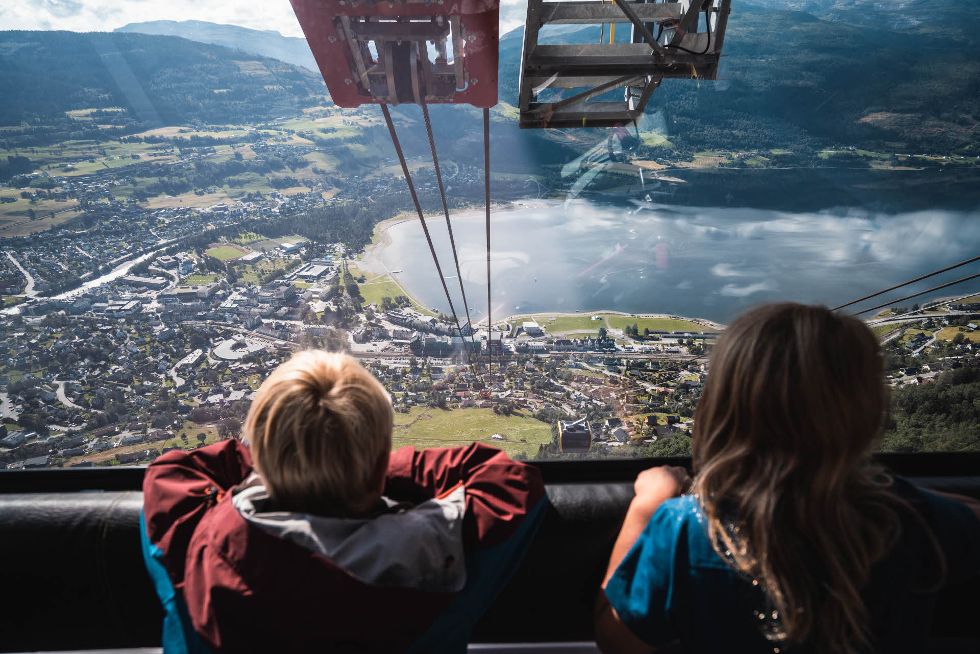 两个孩子站在沃斯贡多拉 (Voss Gondola) 的车厢里俯视沃斯 (Voss) 城镇中心