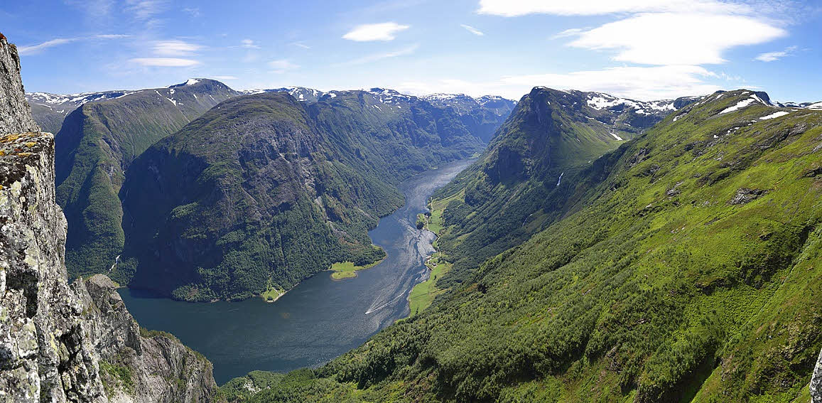 A man sitting at the top of Bakkanosi over the Nærøyfjord