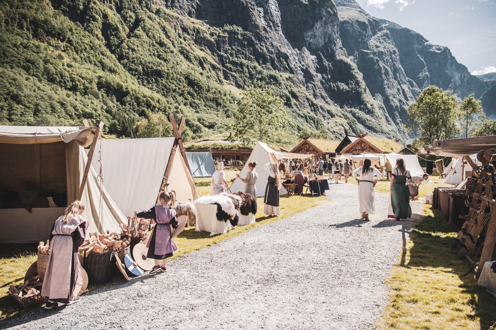 Barn og voksne i vikingdrakter ved autentiske telt i Gudvangen
