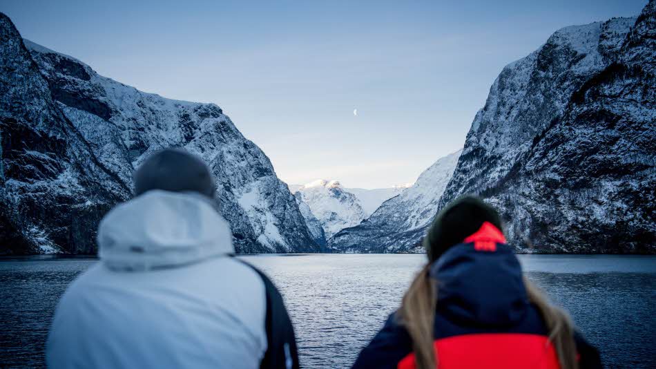 Vista panorámica de una mujer situada en la parte delantera central del Future of The Fjords mientras navega por Nærøyfjord en verano