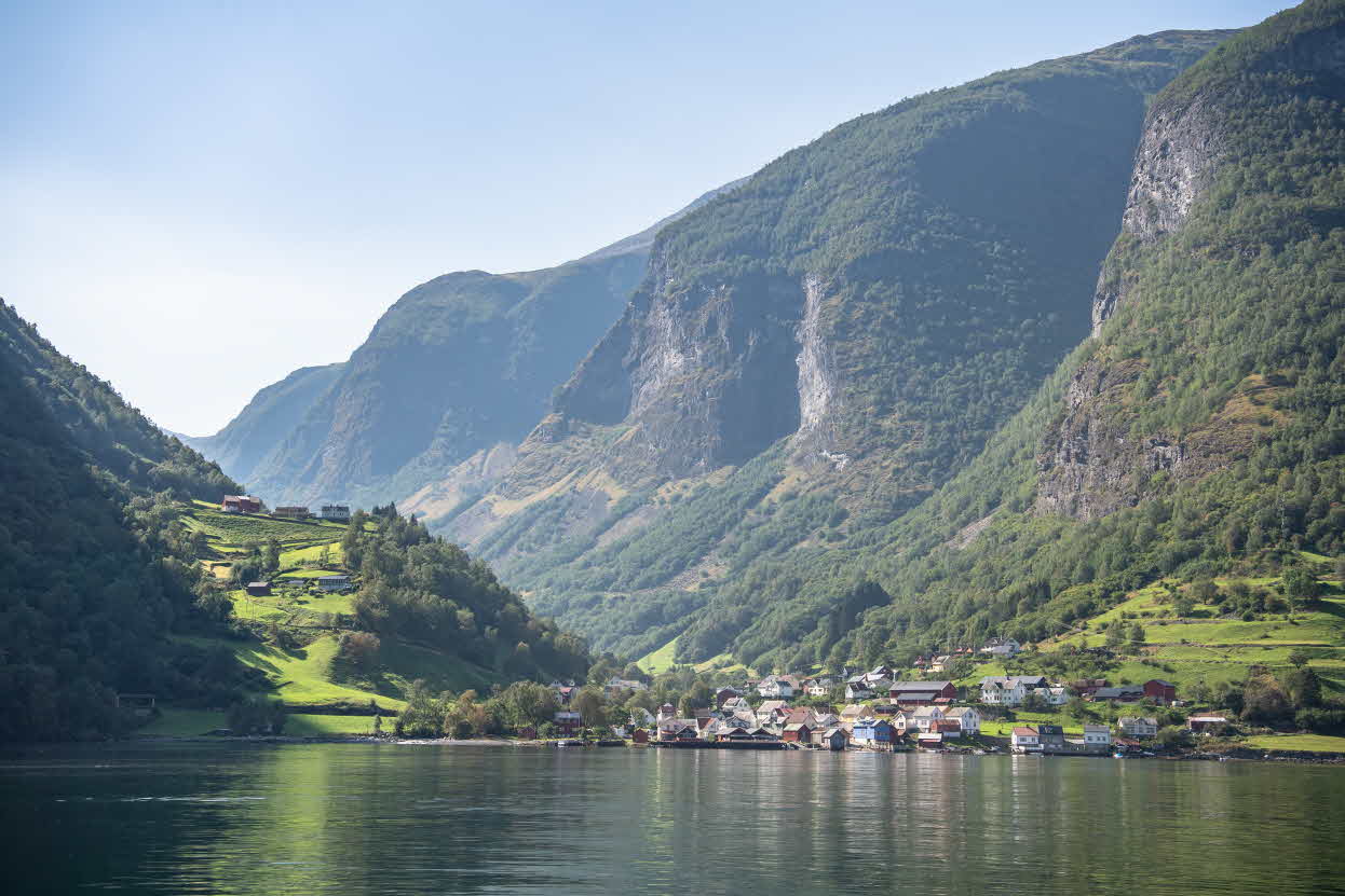 Blick vom Fjord auf Undredal mit steilen Bergen im Hintergrund